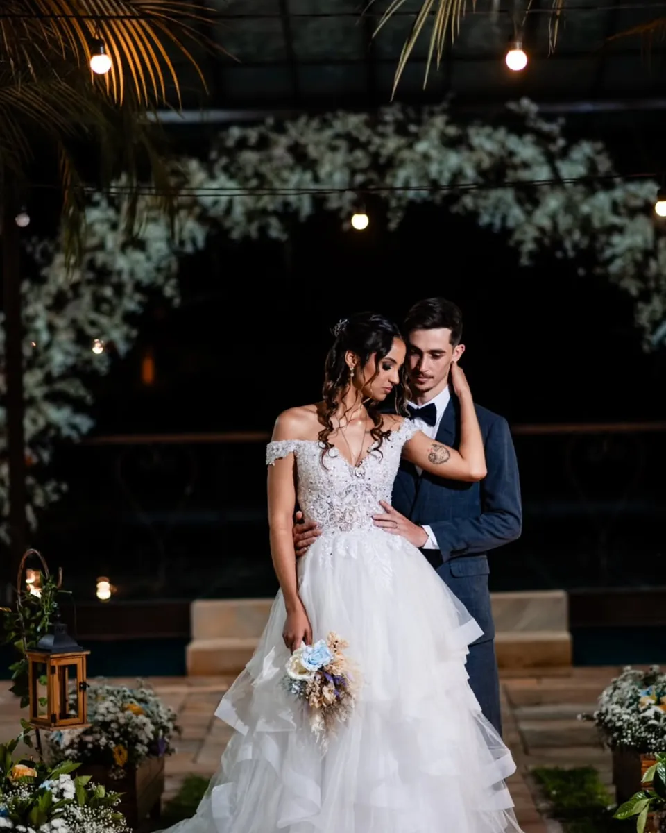 Casal sob iluminação noturna de cerimônia